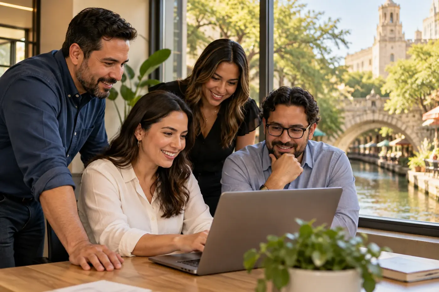 Team reviewing work at a laptop in a San Antonio office